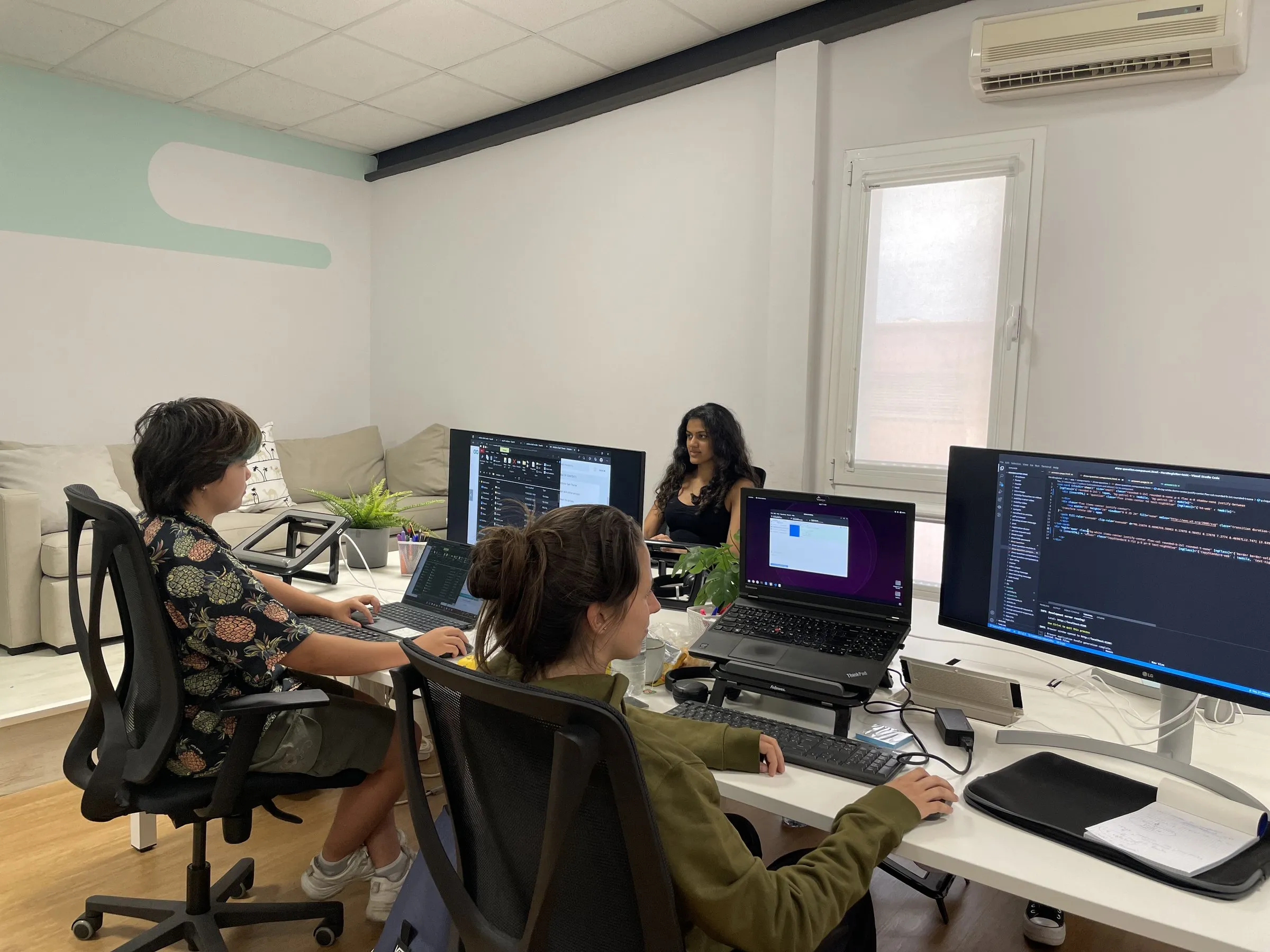 The Calima team at work in the office, with code on the screens