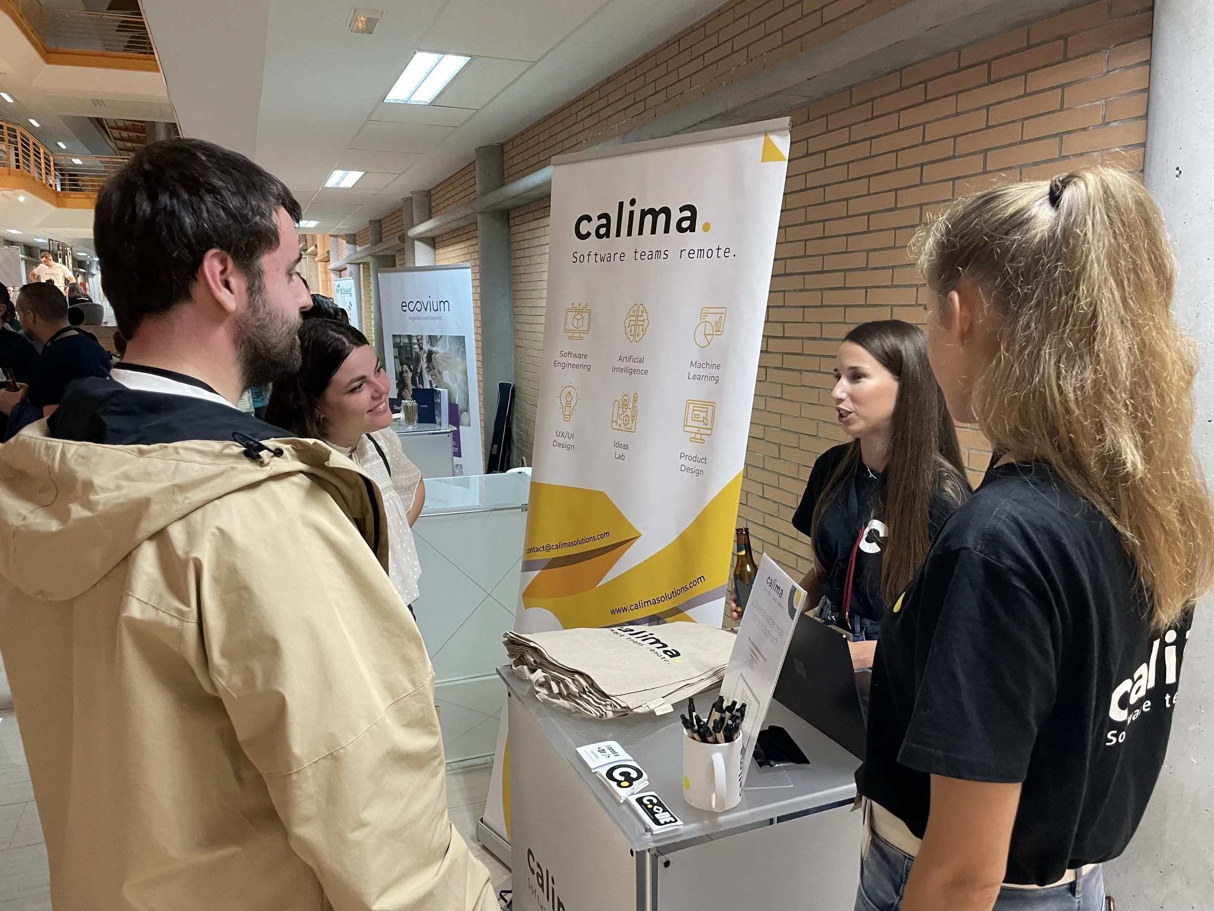 Der Calima-Stand auf einer Tech-Konferenz, Teammitglieder im Gespräch mit Besuchern