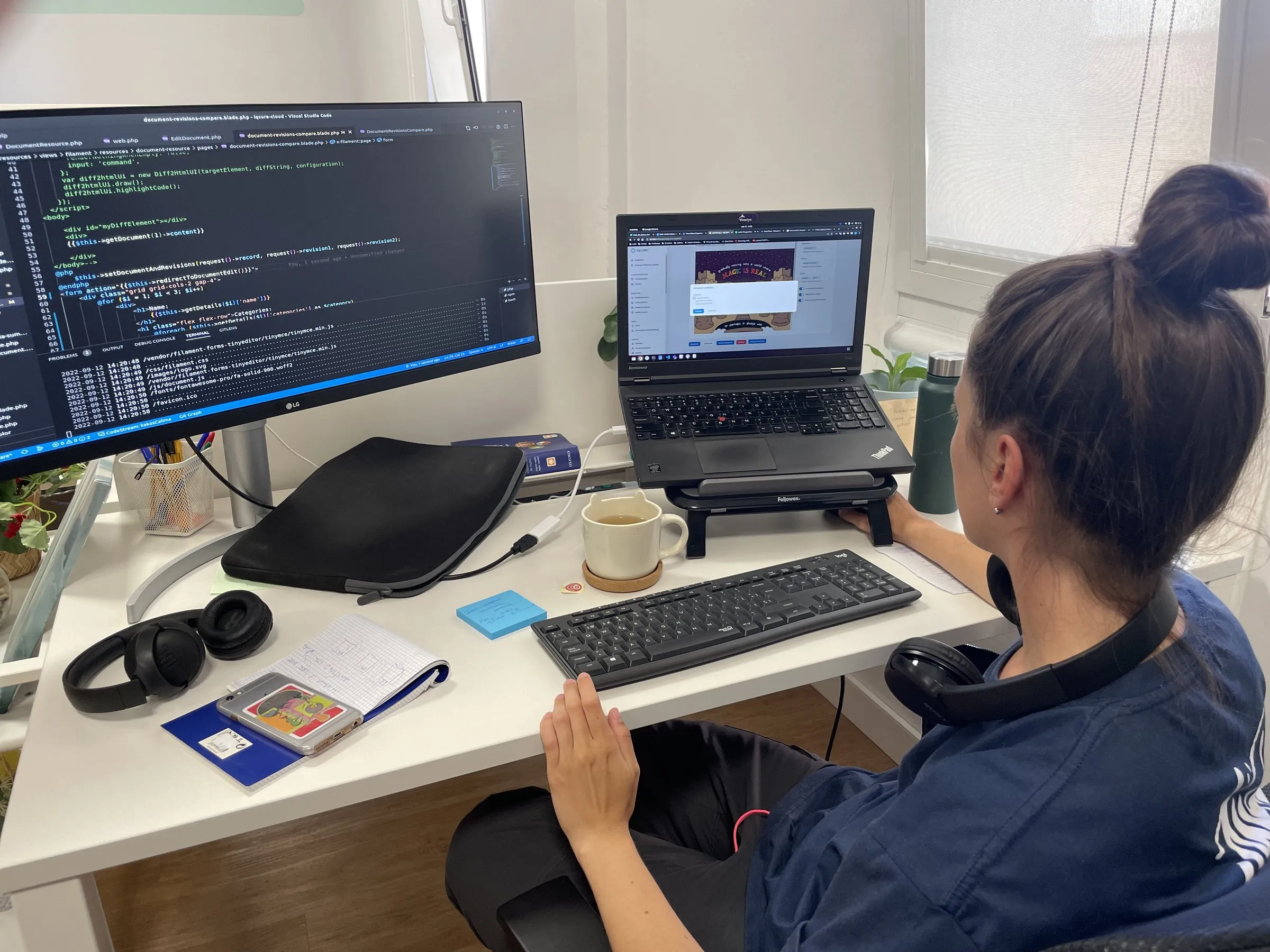 A Calima developer coding at her desk, with code on a large screen