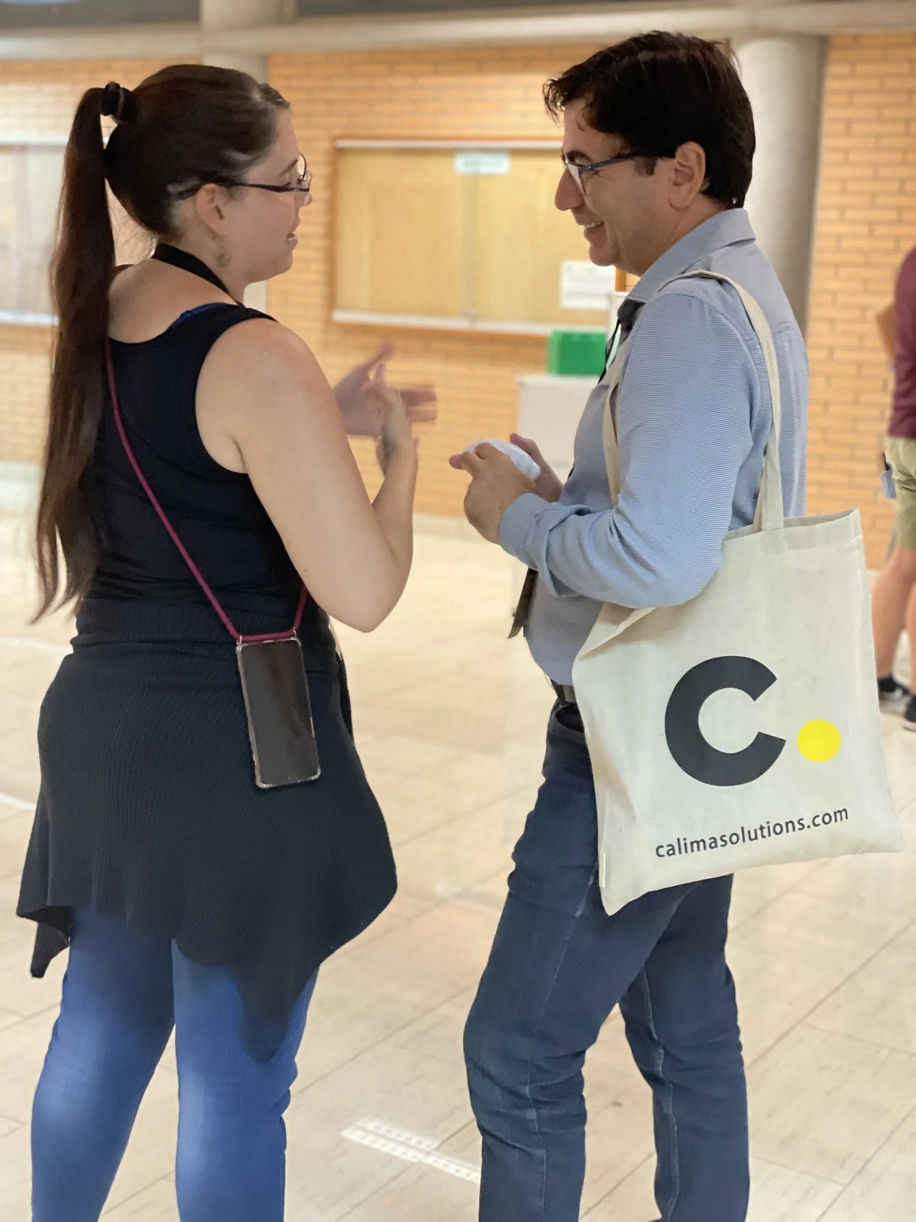 Gespräch mit einem Besucher mit Calima-Tasche auf einer Tech-Konferenz